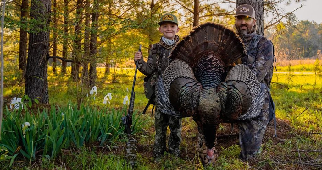 Photo of an adult and youth Georgia turkey hunter with a turkey.
